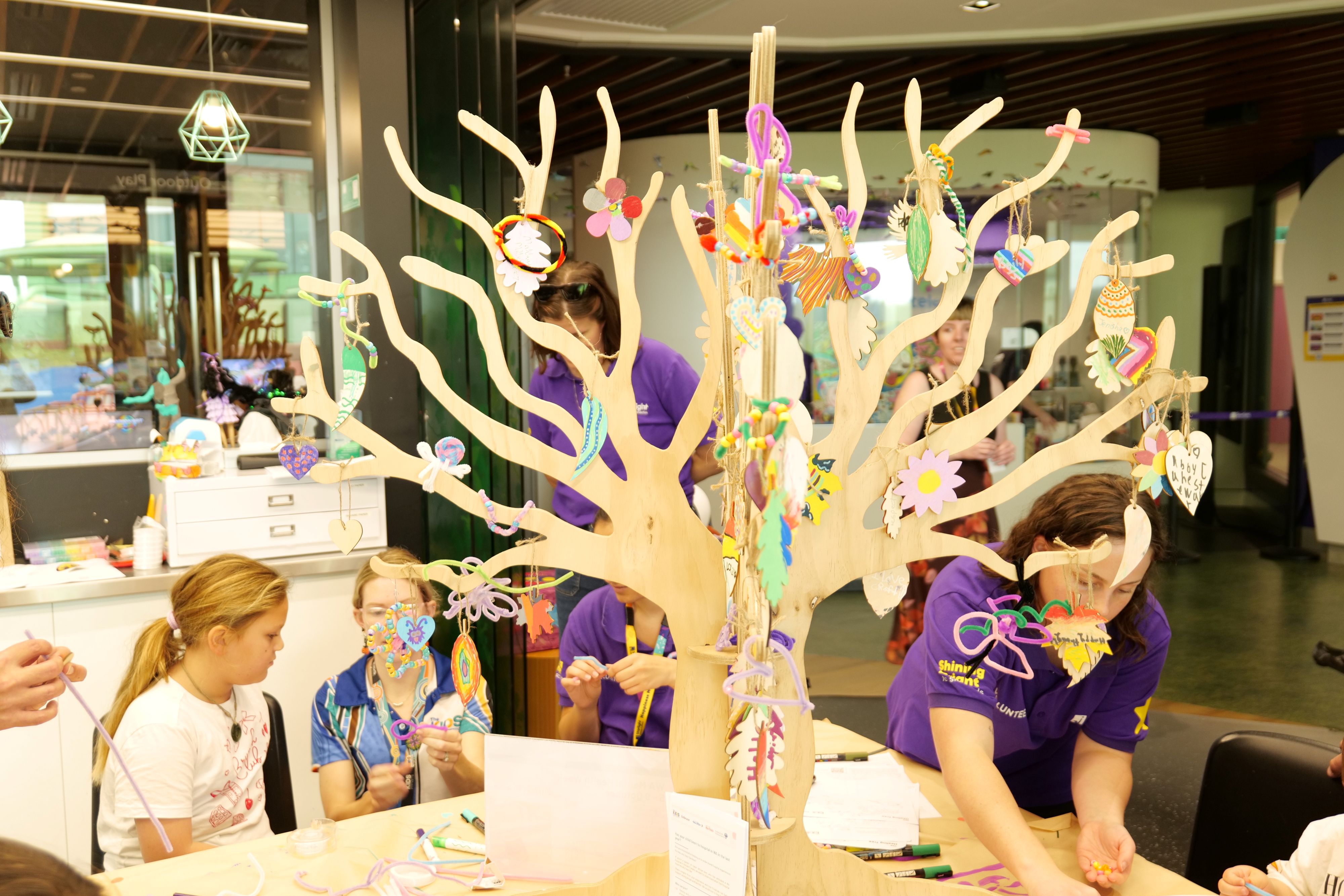 Kids gathered around the tree doing creative activities