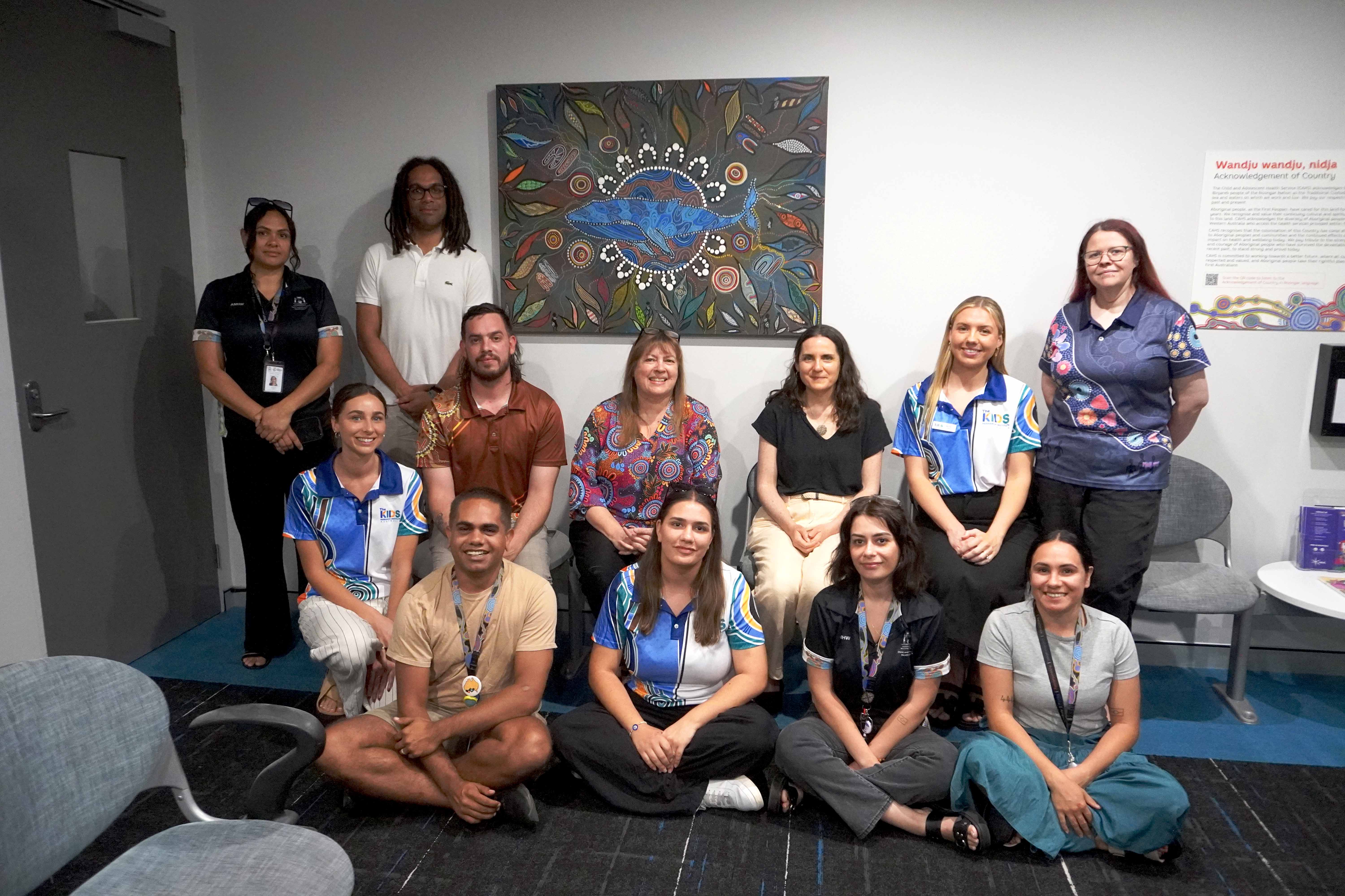 Staff from The Kids and CAMHS sitting under the new painting